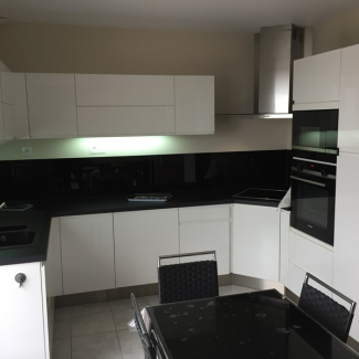 Cuisine blanche sans poignée avec un plan de travail foncé